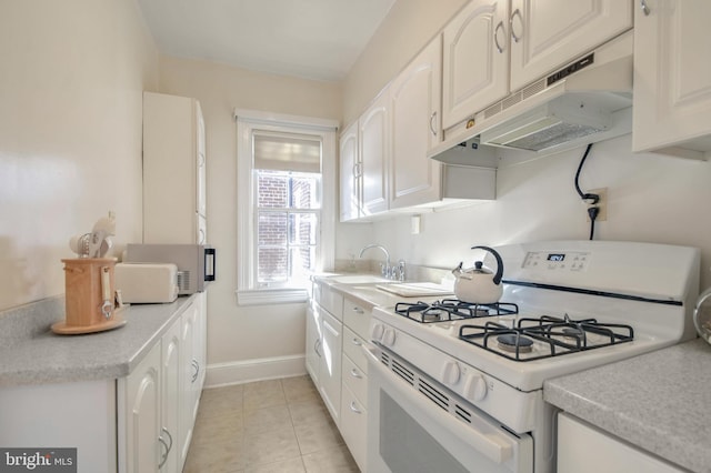 kitchen with white cabinetry, sink, light tile patterned flooring, and white appliances