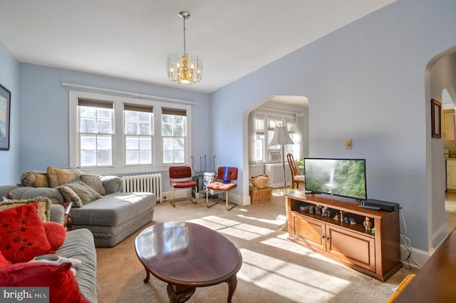 carpeted living room with radiator and an inviting chandelier