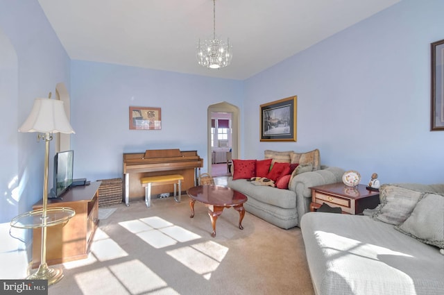 carpeted living room with a notable chandelier