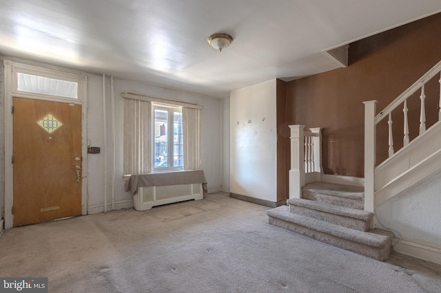 entrance foyer with stairs, baseboards, light colored carpet, and radiator