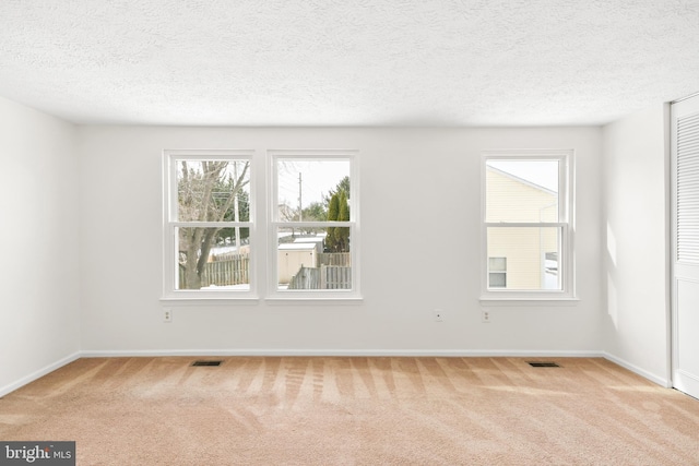 carpeted empty room with a textured ceiling