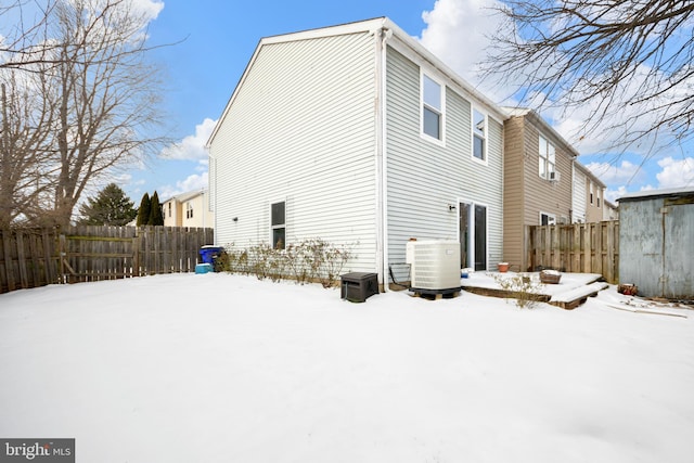 snow covered house featuring central AC