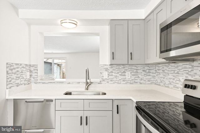 kitchen with gray cabinets, sink, and appliances with stainless steel finishes