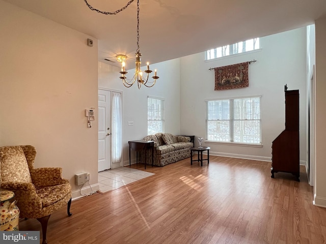 living area with hardwood / wood-style floors, a healthy amount of sunlight, and a chandelier