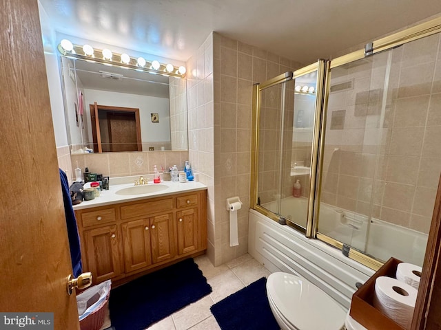 full bathroom with tile patterned flooring, vanity, bath / shower combo with glass door, backsplash, and tile walls