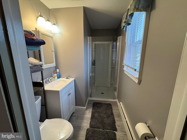 bathroom with a shower with door, a baseboard heating unit, hardwood / wood-style floors, toilet, and vanity