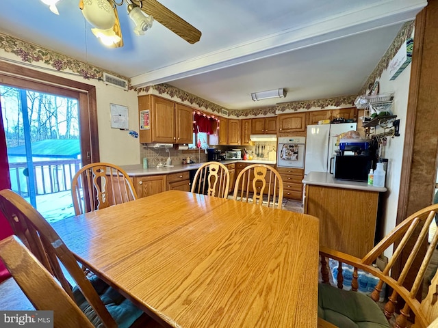 dining room with ceiling fan and beamed ceiling