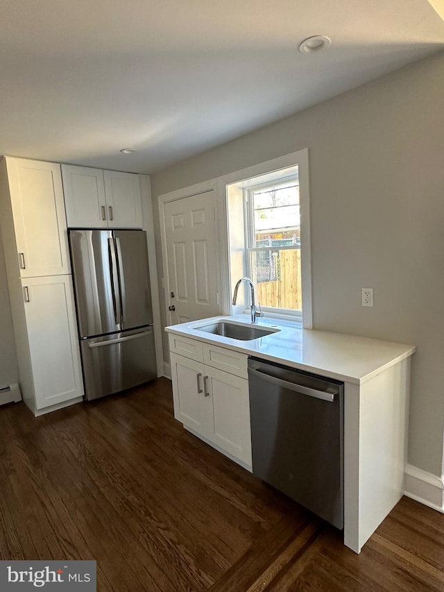 kitchen with white cabinets, dark hardwood / wood-style floors, sink, and stainless steel appliances