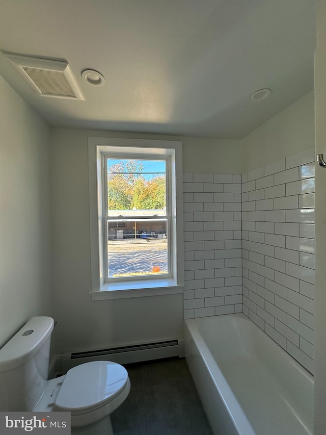 bathroom featuring toilet, tile patterned flooring, tiled shower / bath combo, and a baseboard heating unit