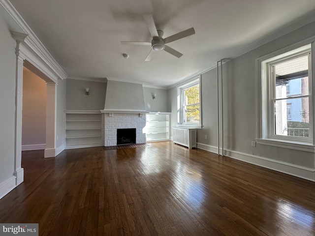 unfurnished living room with radiator heating unit, a brick fireplace, ceiling fan, and crown molding