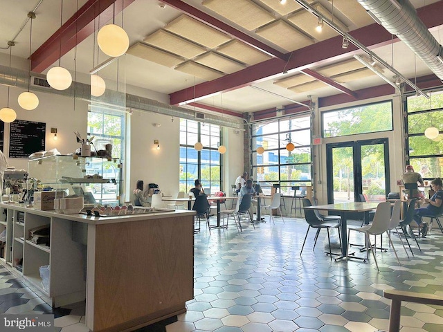 kitchen with pendant lighting, a towering ceiling, and french doors