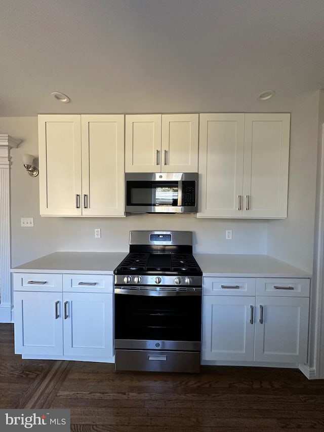 kitchen featuring dark hardwood / wood-style flooring, white cabinetry, and stainless steel appliances