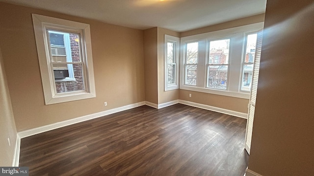 unfurnished room with dark hardwood / wood-style flooring