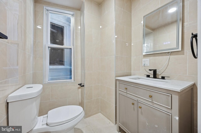 bathroom featuring toilet, tile walls, and vanity