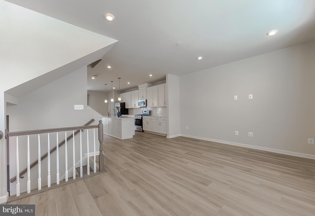 unfurnished living room with sink and light hardwood / wood-style floors