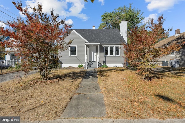 bungalow-style house with cooling unit and a front yard