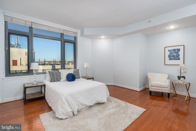 bedroom with hardwood / wood-style flooring and expansive windows