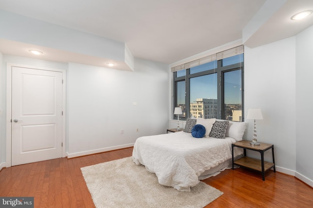 bedroom featuring a wall of windows and wood-type flooring