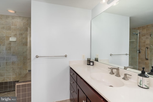 bathroom featuring a tile shower, tile patterned flooring, and vanity