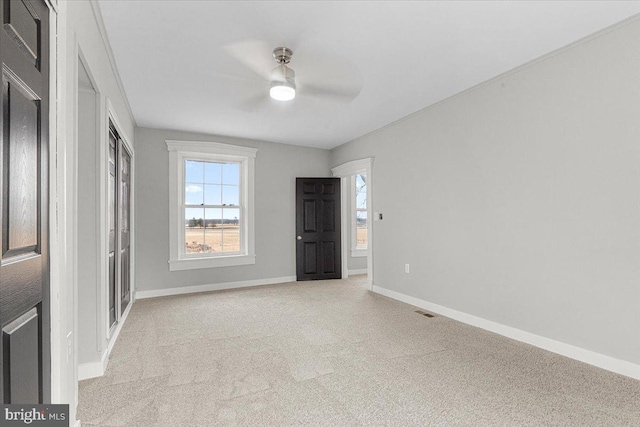 unfurnished bedroom with a closet, visible vents, a ceiling fan, light carpet, and baseboards