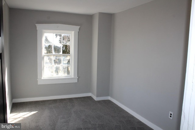 carpeted spare room featuring baseboards