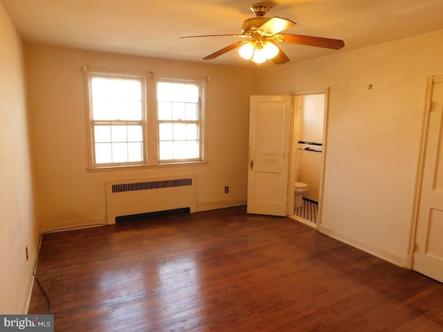 unfurnished bedroom featuring radiator heating unit, dark hardwood / wood-style floors, and ensuite bathroom