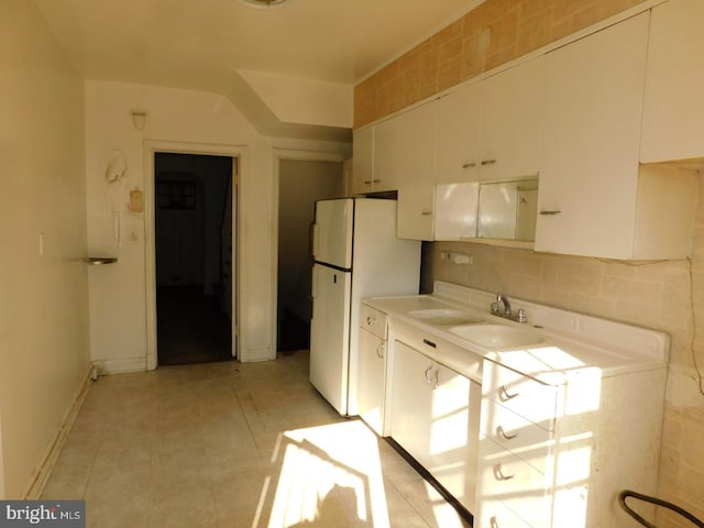 kitchen featuring white cabinetry, white fridge, sink, and light tile patterned floors