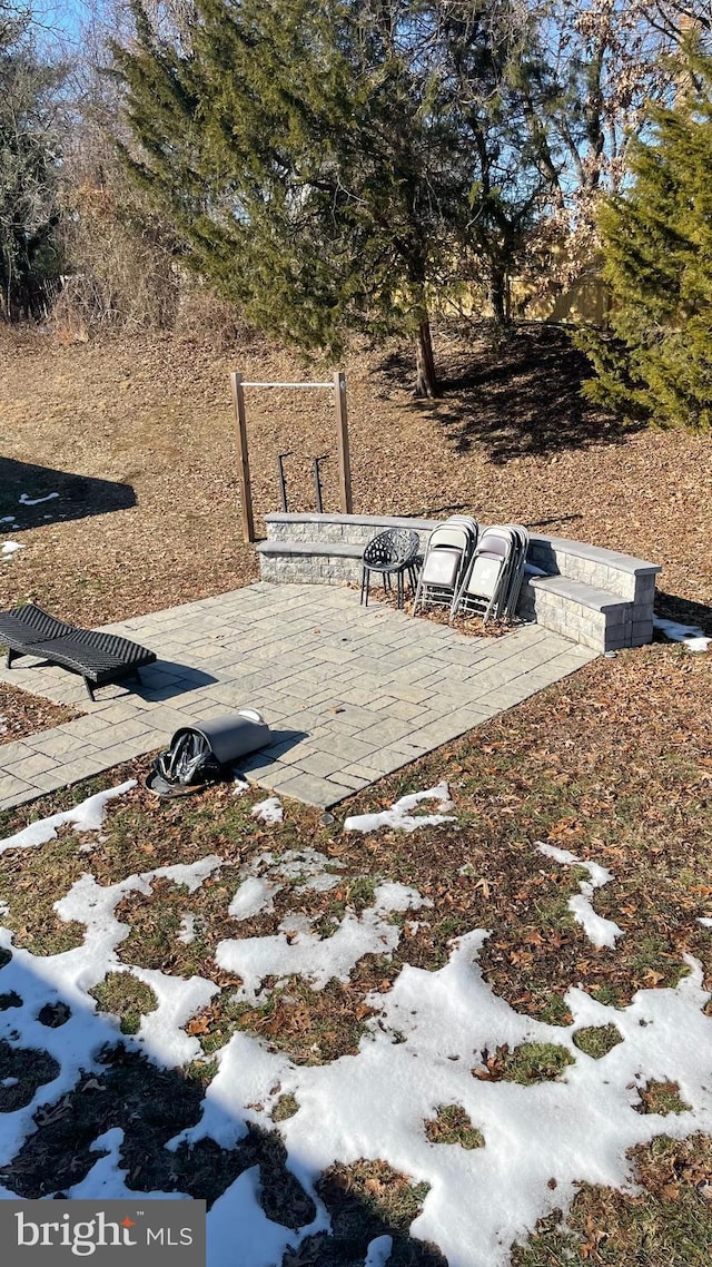 snowy yard featuring a patio area