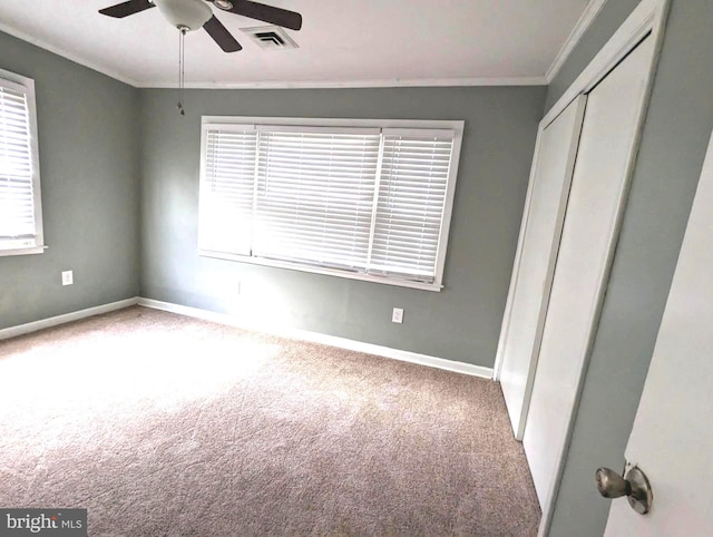 unfurnished bedroom with carpet, a closet, ceiling fan, and ornamental molding