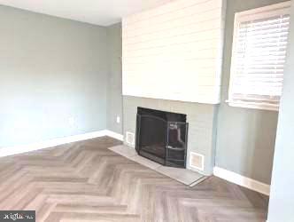 unfurnished living room featuring parquet floors and a fireplace