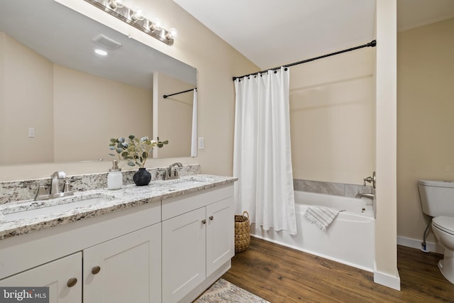 full bathroom with hardwood / wood-style flooring, vanity, shower / tub combo with curtain, and toilet