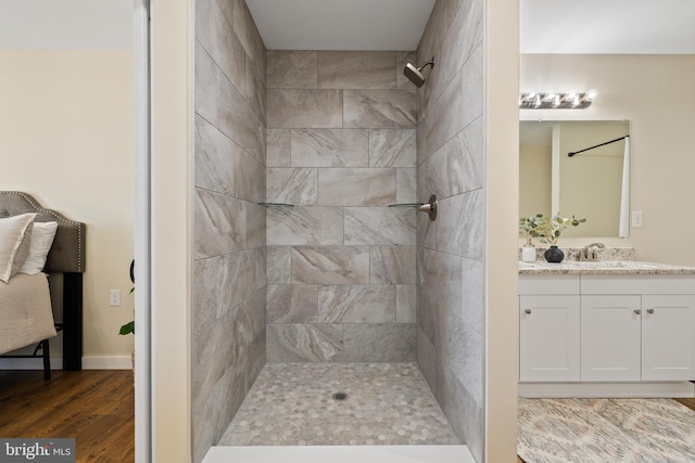 bathroom with vanity, hardwood / wood-style flooring, and a tile shower