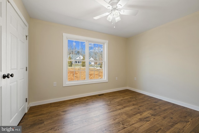 empty room with ceiling fan and dark hardwood / wood-style floors