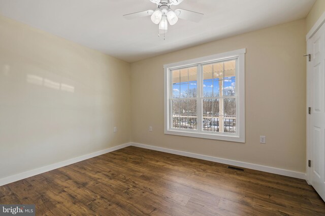 unfurnished room featuring dark hardwood / wood-style flooring, a wealth of natural light, and ceiling fan