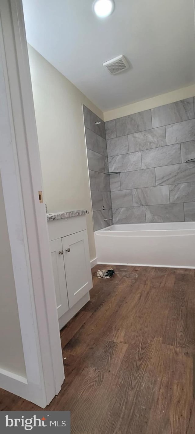 bathroom with tiled shower / bath combo and wood-type flooring