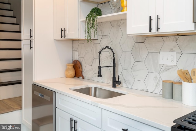 kitchen with sink, dishwasher, and white cabinetry