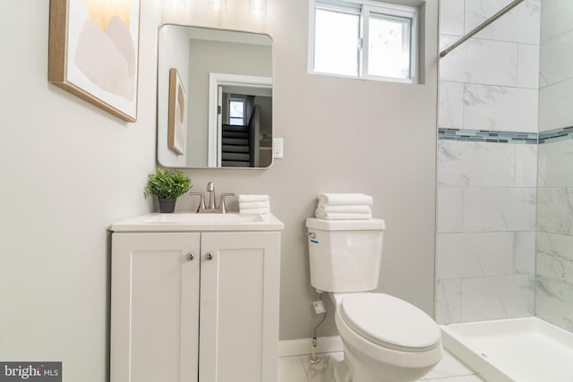 bathroom featuring vanity, toilet, tiled shower, and tile patterned flooring