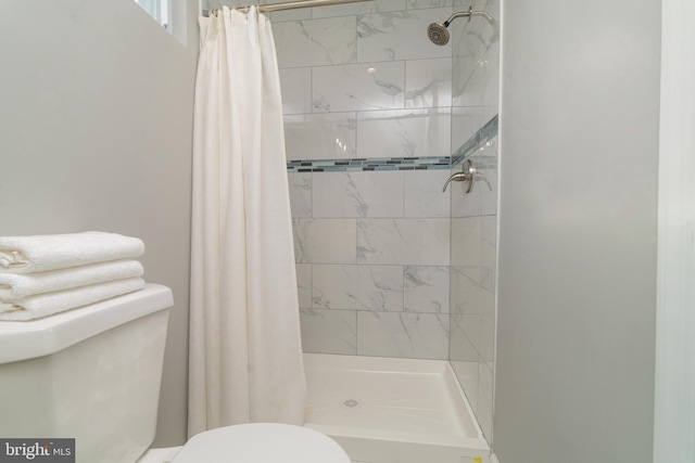 bathroom with curtained shower and toilet