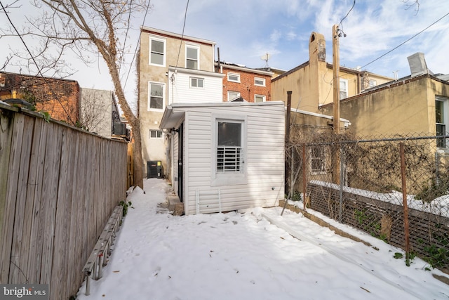 snow covered rear of property with central air condition unit