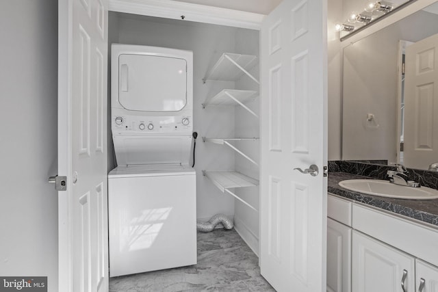 laundry area featuring stacked washer and clothes dryer and sink