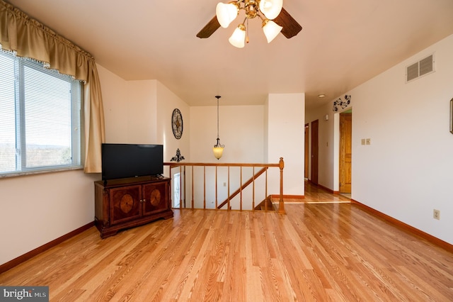 living room with light wood-type flooring and ceiling fan