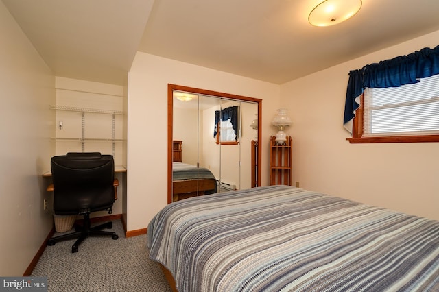 bedroom with carpet flooring, a closet, and a baseboard heating unit