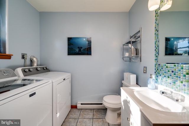 bathroom featuring vanity, washer and clothes dryer, baseboard heating, tile patterned flooring, and toilet