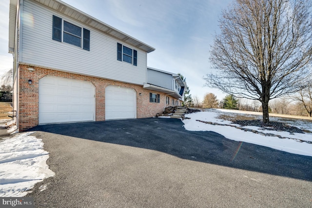 snow covered property with a garage