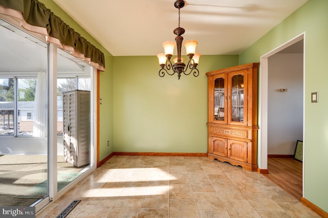 unfurnished dining area with a notable chandelier