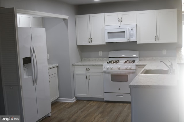 kitchen with dark hardwood / wood-style floors, white cabinetry, white appliances, and sink