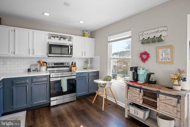 kitchen with blue cabinetry, white cabinetry, stainless steel appliances, tasteful backsplash, and dark hardwood / wood-style flooring