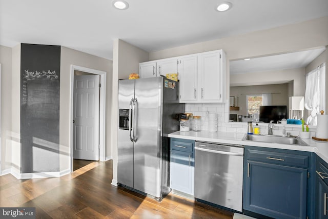 kitchen featuring blue cabinets, decorative backsplash, dark hardwood / wood-style flooring, white cabinetry, and stainless steel appliances