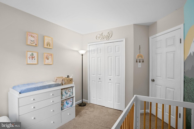 bedroom with a closet, a nursery area, and light colored carpet