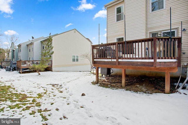 snow covered house featuring a deck and central air condition unit